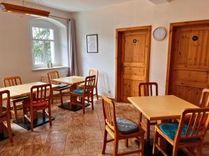 a restaurant with tables and chairs and a clock on the wall at SB-"PENSION Berggasse" - Gemeinschaftsküche, WIFI, Smart-TV, Zentral! in Olbernhau
