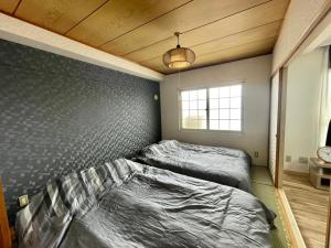 a bedroom with two beds and a wall at Ueda Building - Vacation STAY 13581 in Asahikawa
