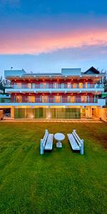 ウーティにあるOoty Blossom Retreat by VOYE HOMESの正面にテーブルとベンチが備わる建物