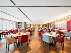 a restaurant with tables and chairs in a room at Guiyang Airport Outlets Yicheng Hotel 