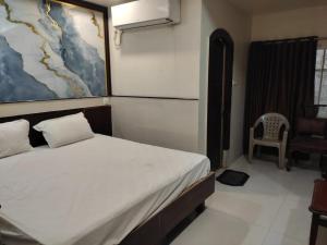 a bedroom with a bed and a chair in it at HoTEL TANIYA in Vijayawāda +45 photos