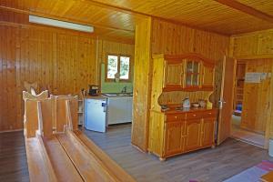 a kitchen with wooden walls and a white refrigerator at Grand Lodge in Finhaut