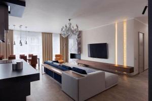 Una sala de estar con un sofá y un televisor. en Апартаменти, en Gorishni Plavni