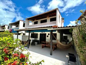 une maison avec un patio avec une table et un banc dans l'établissement Casa Privê Maragogi 26 - Pé na areia, à Maragogi