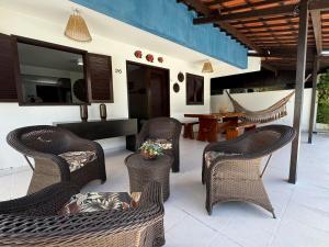 un patio extérieur avec des chaises en osier et une table dans l'établissement Casa Privê Maragogi 26 - Pé na areia, à Maragogi