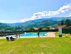 a group of people sitting around a swimming pool at La casa del Río in Pujayo
