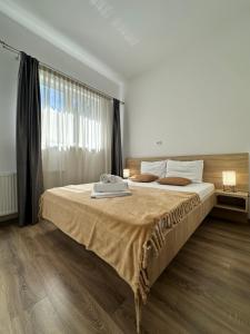 Un dormitorio con una cama grande con una ventana grande. en 27 RENT Apartments, en Bucarest