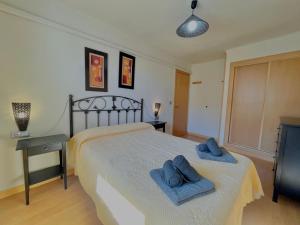 a bedroom with a bed with two blue towels on it at Apartamentos Terrasol BARCO 5 in Torre del Mar