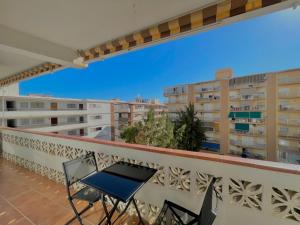 a balcony with a table and chairs and buildings at Apartamentos Terrasol BARCO 5 in Torre del Mar