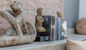 a shelf with books and a statue on it at Villa Dunia Lembongan in Nusa Lembongan