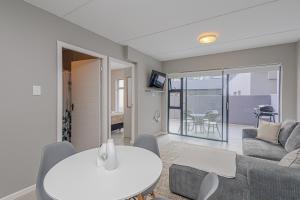 ランゲバーンにあるArch House Langebaan - Modern Stay Near Beach & Club Mykonosのソファとテーブルのあるリビングルーム