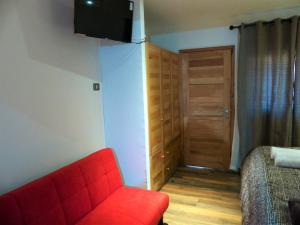 Habitación con sofá rojo y puerta en HOTEL & HOSTAL CHIL'IN, Las Trancas, en Las Trancas