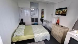 a small bedroom with a bed and a dresser at Résidence La Montagne Studio in Tambe