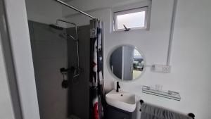 a bathroom with a shower and a sink and a mirror at Résidence La Montagne Studio in Tambe