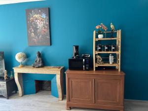 a blue room with a wooden table and a wooden book shelf at CHINATOWN DREAM By MIMI in Dole