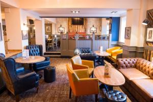 a restaurant with tables and chairs and a bar at Old Grey Mare Inn by Greene King Inns in Hull