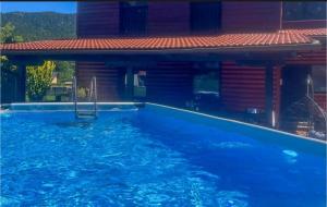 a swimming pool in front of a house at Forest house AVA in Jasenak