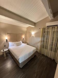 Un dormitorio con una gran cama blanca y una ventana. en The Mazet, en Cannes 13 fotos más
