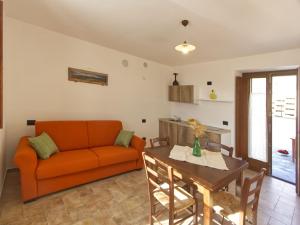 ein Wohnzimmer mit einem orangenen Sofa und einem Tisch in der Unterkunft Escape with Pool & WiFi in Carpegna + 34 Fotos