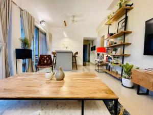 a living room with a wooden table and a couch at Modern Luxe 2BHK Pune in Pune