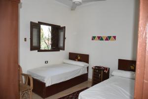 Ένα ή περισσότερα κρεβάτια σε δωμάτιο στο النبلاء جيست هاوس نوبيان اسوان