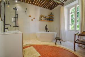 a bathroom with a large tub and a sink at Maison Maples- Le charme provençal in Villecroze +46 photos