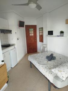 a room with a bed and a kitchen with a door at Estudio Sota-Piscina in Denia
