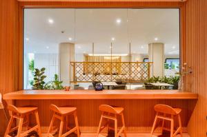 a restaurant with a bar with four stools at Chalong Marina Bay View Rawai Phuket in Rawai Beach