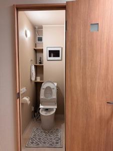 a bathroom with a toilet with the lid up at Cozy House Namba in Osaka