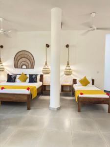 a bedroom with two beds and two pendant lights at Olzadia Boutique Hotel in Michamvi +61 photos