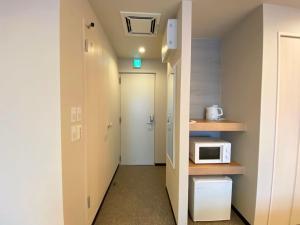 a small room with a microwave and a hallway at winco - Vacation STAY 06658v in Tokyo +9 photos
