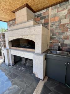 an outdoor kitchen with a stone fireplace at Amora Guesthouse in Ashtarak