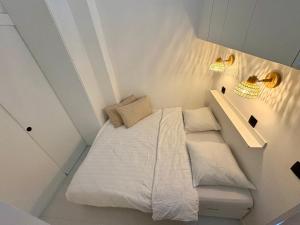 een kleine slaapkamer met een wit bed en verlichting bij SEA VIEW Juweeltje in Knokke-Heist