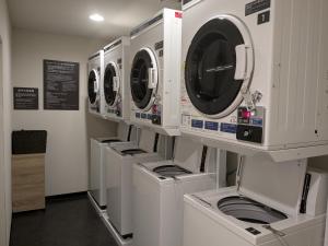 una fila de lavadoras en una lavandería en Dormy Inn Express Sendai Hirose Dori, en Sendai