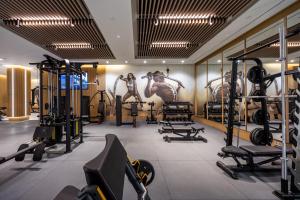 a gym with several tread machines and a mural of horses at Hipotels Barrosa Garden in Chiclana de la Frontera