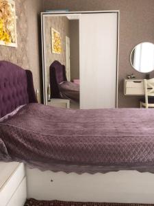 1 dormitorio con cama morada y espejo en Villa Goradil, en Mekhrably