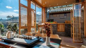 een keuken met een tafel en stoelen en een groot raam bij Nostalgia 28 lodge in Baisha