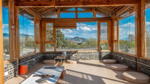 een grote kamer met een tafel en een aantal ramen bij Nostalgia 28 lodge in Baisha