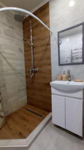 a bathroom with a shower and a sink and a mirror at Olena's apartment in Berehove +8 photos