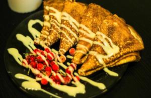 a plate of food with waffles and berries on it at Guest House Väikesaare in Narva +16 photos
