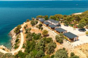 プリモシュテンにあるCAMP ADRIATIC MOBILE HOMES - PRIMOŠTENの水辺の丘の上の家屋