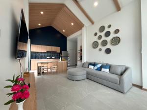 un salon avec un canapé et une cuisine dans l'établissement Aonang Selena Pool Villa, à Ban Chong Phli