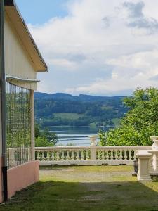 una casa con una recinzione e una vista sul lago di Épiléa la romantique au bord du lac a Aiguebelette-le-Lac