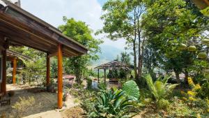 a garden with a table and an umbrella at Giay's Local House in Sapa