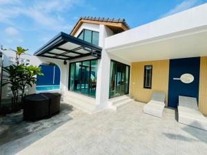 Cette maison dispose d'une terrasse avec 2 chaises. dans l'établissement Aonang Selena Pool Villa, à Ban Chong Phli