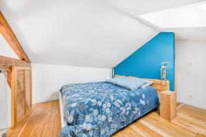 a bedroom with a bed with a blue headboard at La Grange Aux Arbres - Le Tulipier in Baron