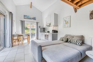 a living room with a couch and a kitchen at La Grange Aux Arbres - Le Tulipier in Baron