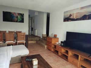 Una sala de estar con un televisor de pantalla plana grande. en apto 2 hab y jardín cerca de Alcalá de Henares, en Villalbilla