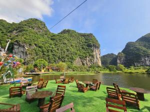a group of chairs and tables in front of a lake at An Riverside Ecolodge in Nguyên Ngoại