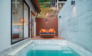 una piscina con una silla al lado de una casa en Vianna Villas Chiangmai, en Mae Rim